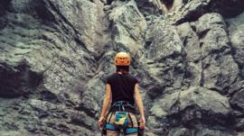 Female climber looks at rockface